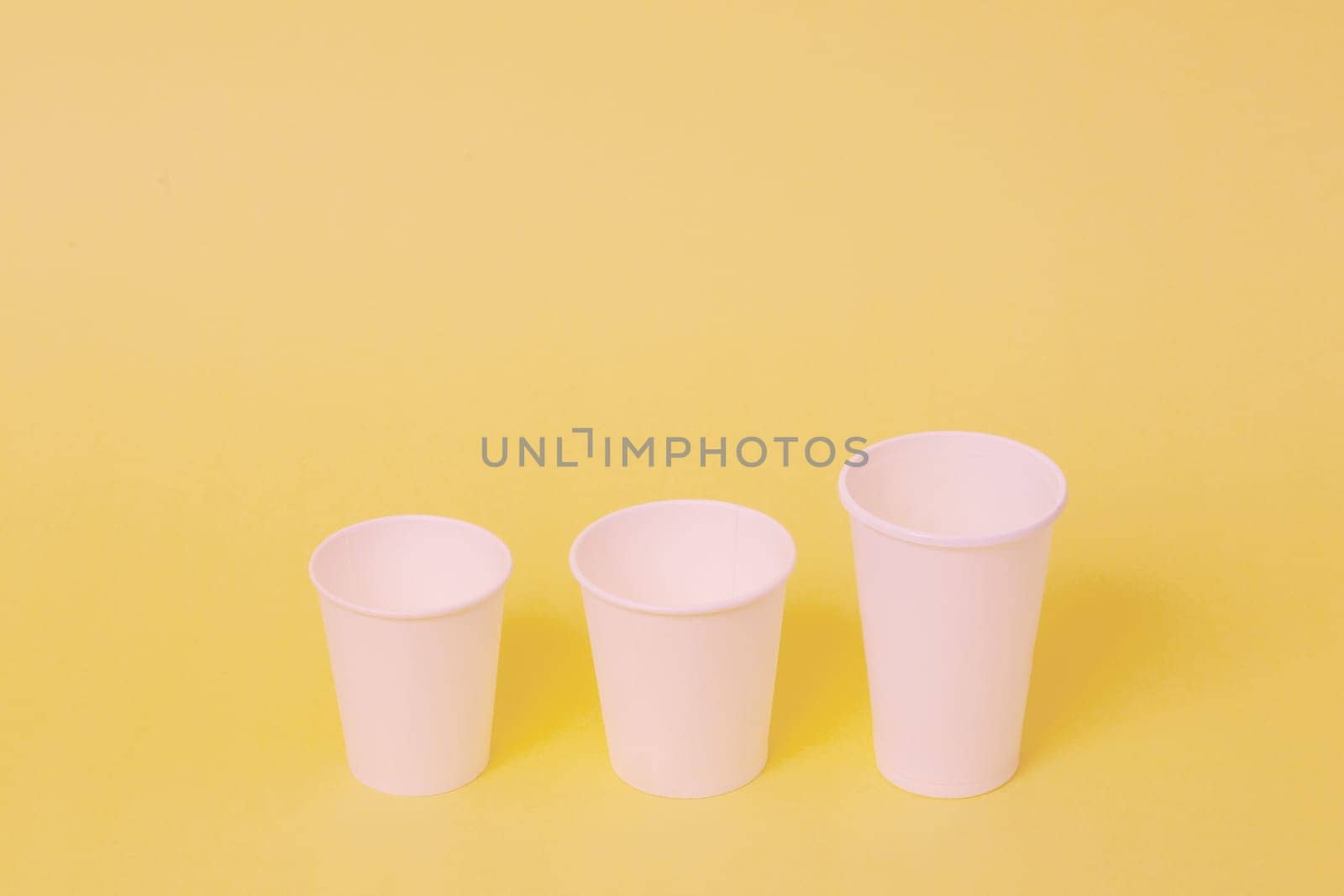 Take away a cup of coffee on orange paper background.
