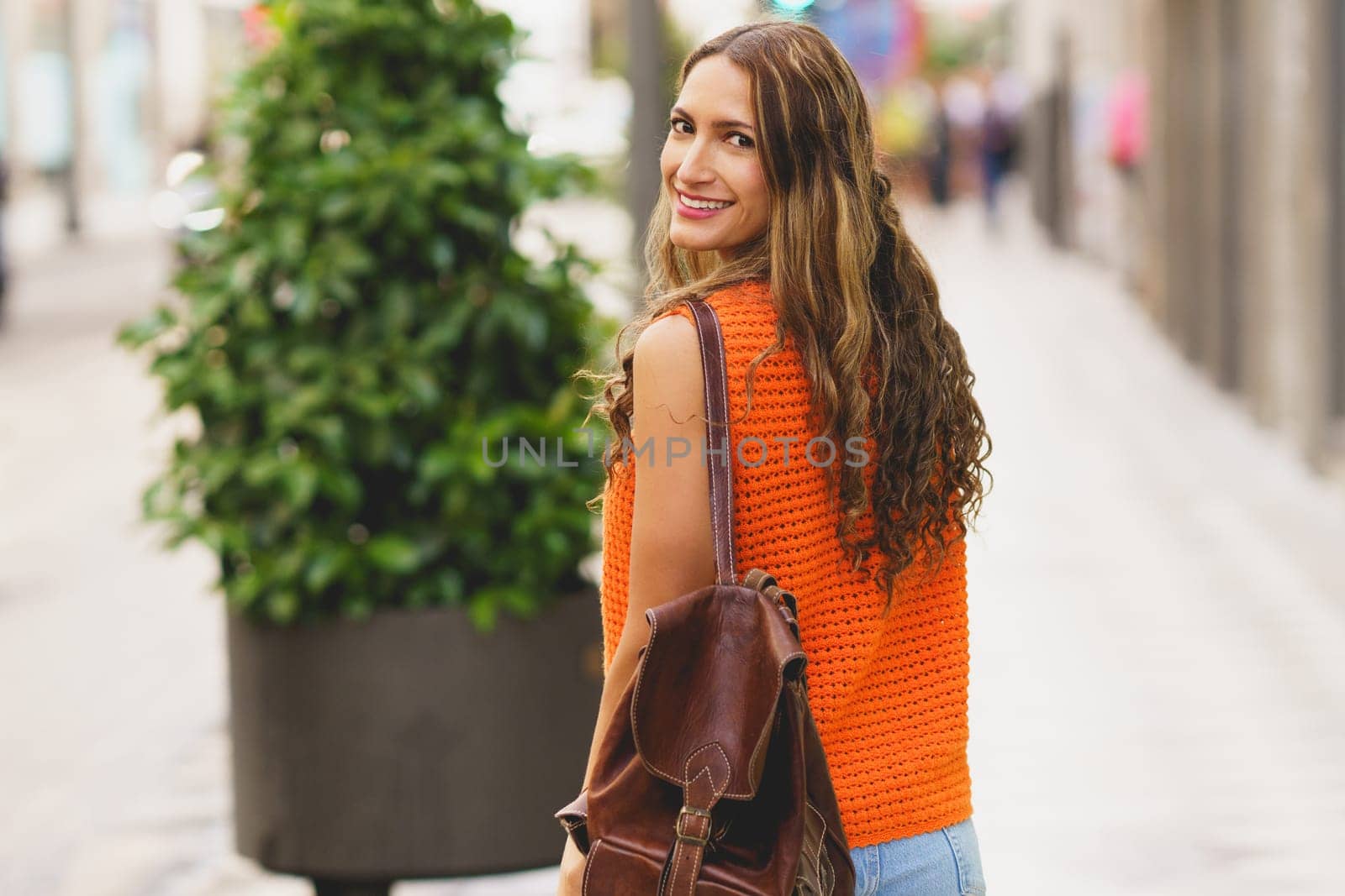 Casual latin woman smile in the city while walking