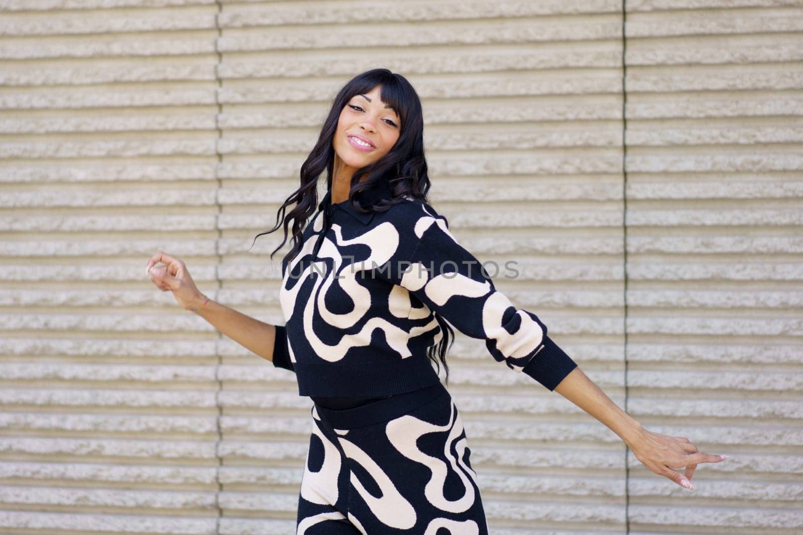 Passionate hispanic beauty dancer smiling at camera while performing in the city