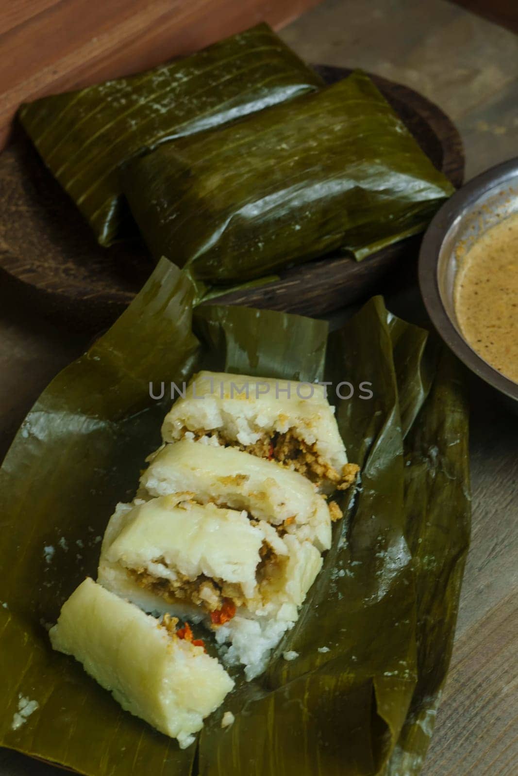 Lontong oncom, a traditional Indonesian dish with steamed rice cakes wrapped in banana leaves, served with spicy peanut sauce.