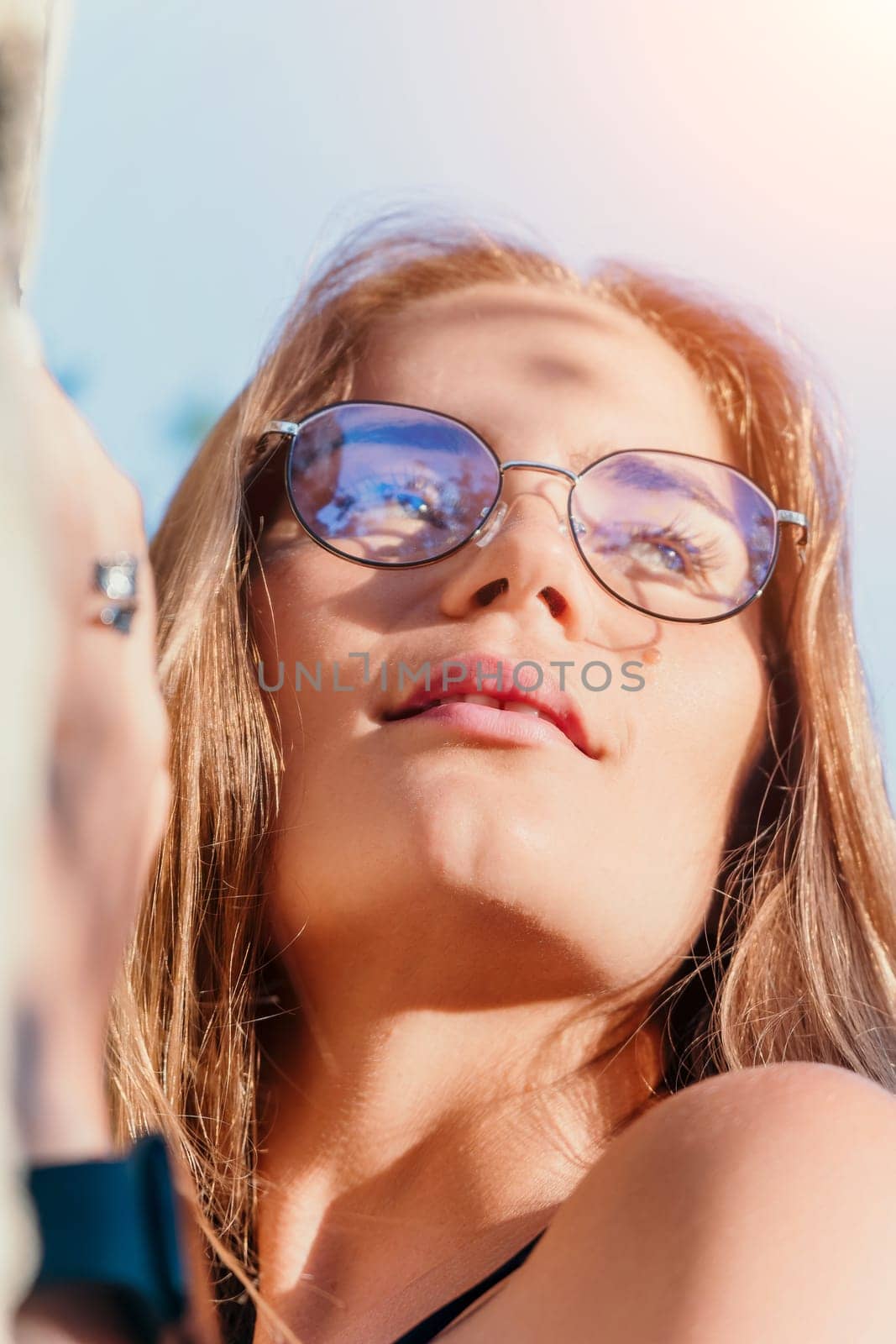 Woman travel sea. Young Happy woman in a long red dress posing on a beach near the sea on background of volcanic rocks, like in Iceland, sharing travel adventure journey