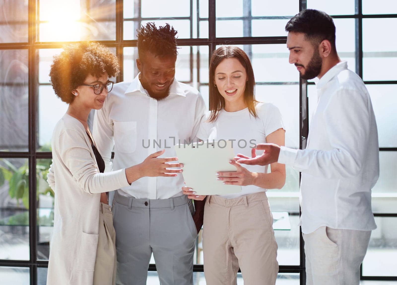 Happy young female employee discussing online project, showing computer presentation to skilled team leader in eyeglasses. Friendly diverse colleagues working in pairs on laptop, using applications.