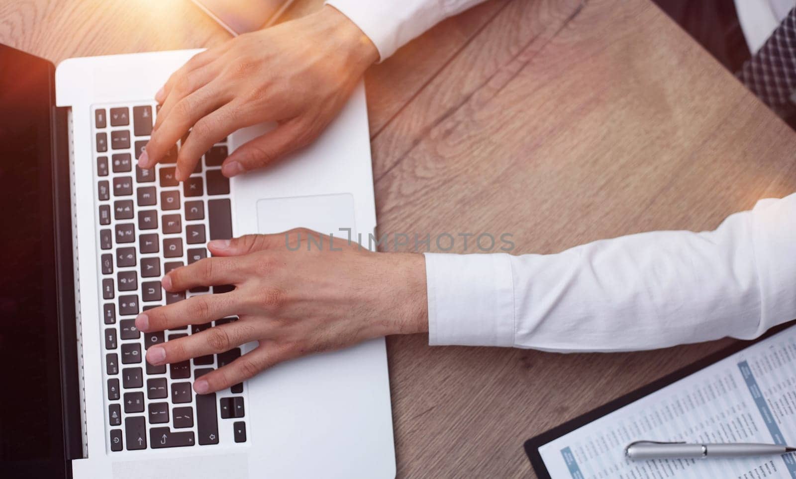Businessman working with laptop and documents sitting at office desk