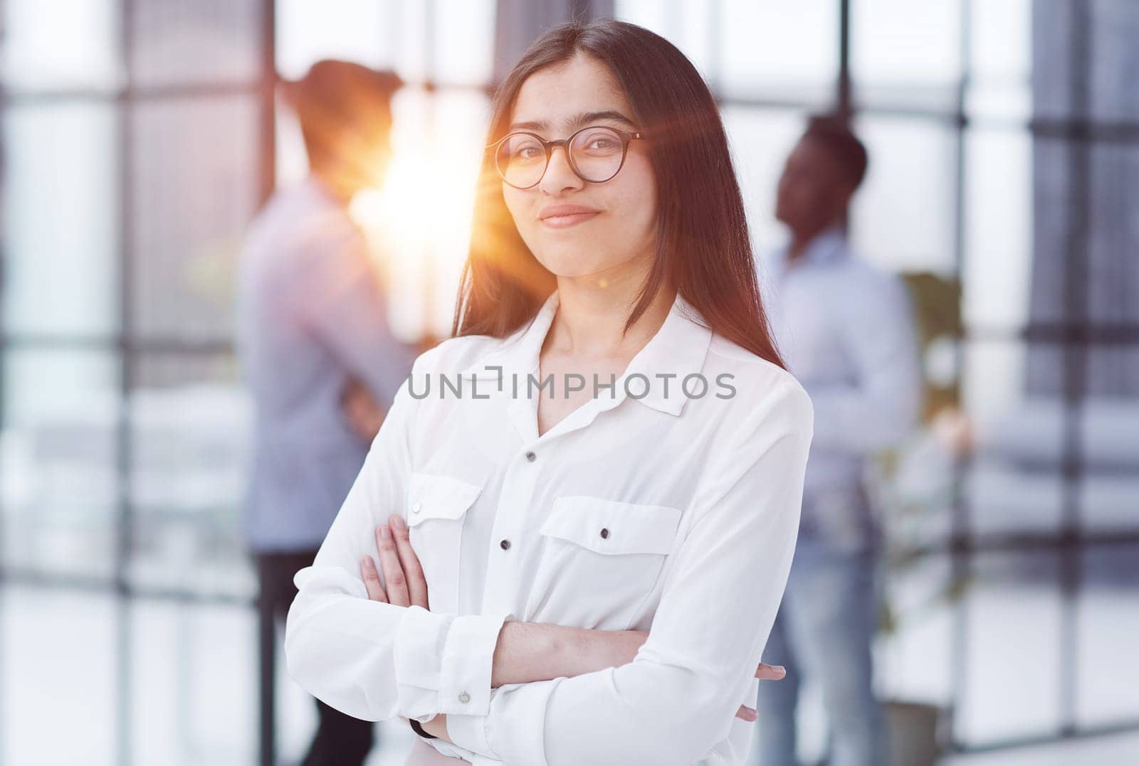 a girl stands in a modern office and looks at the camera