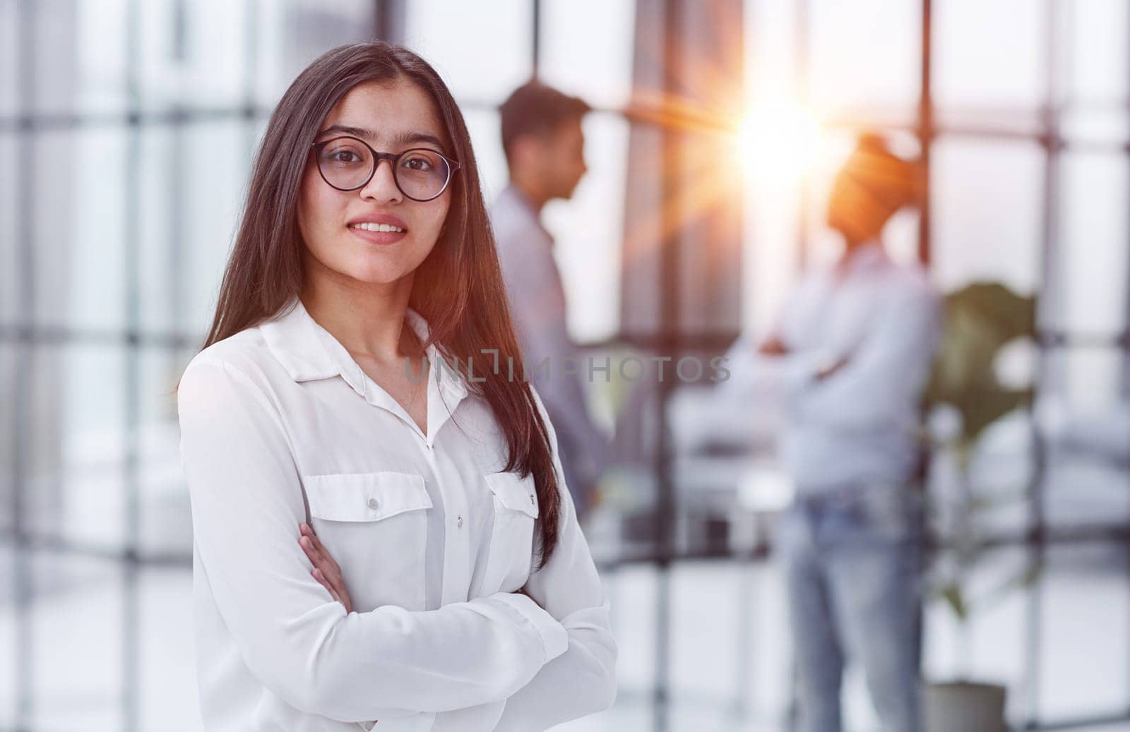 a girl stands in a modern office and looks at the camera