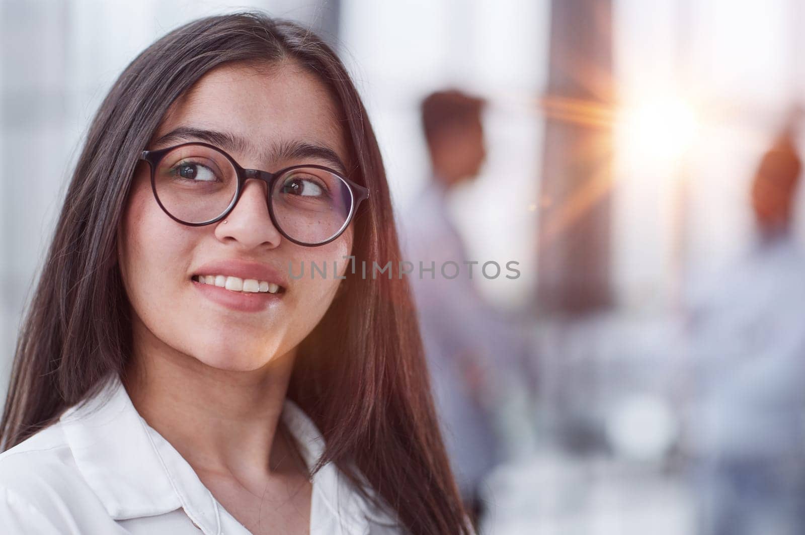 a girl stands in a modern office and looks at the camera