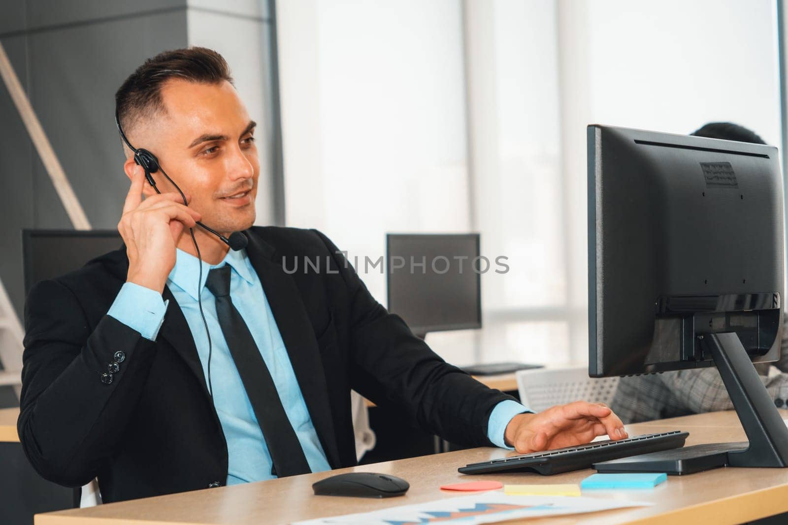 Business people wearing headset working in office to support remote customer or colleague. Call center, telemarketing, customer support agent provide service on telephone video conference call. Jivy