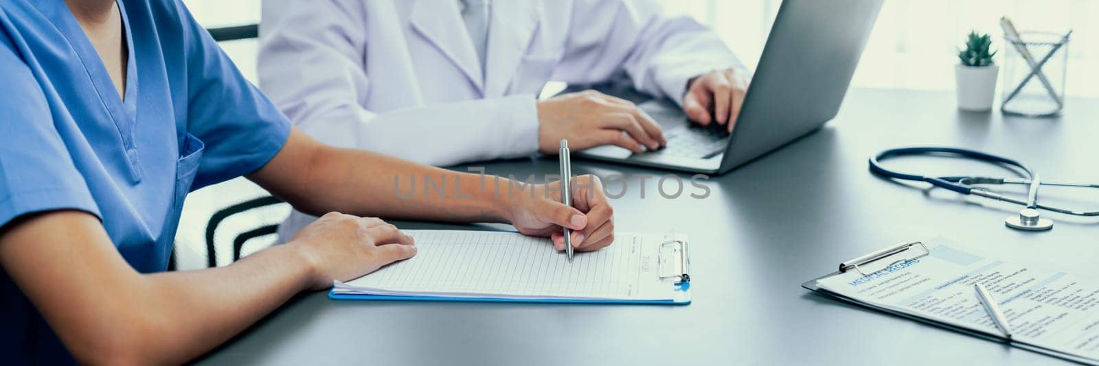 Doctor and nurse in medical meeting discussing strategic medical treatment plan together with report and laptop. Medical school workshop training concept in panoramic banner. Neoteric