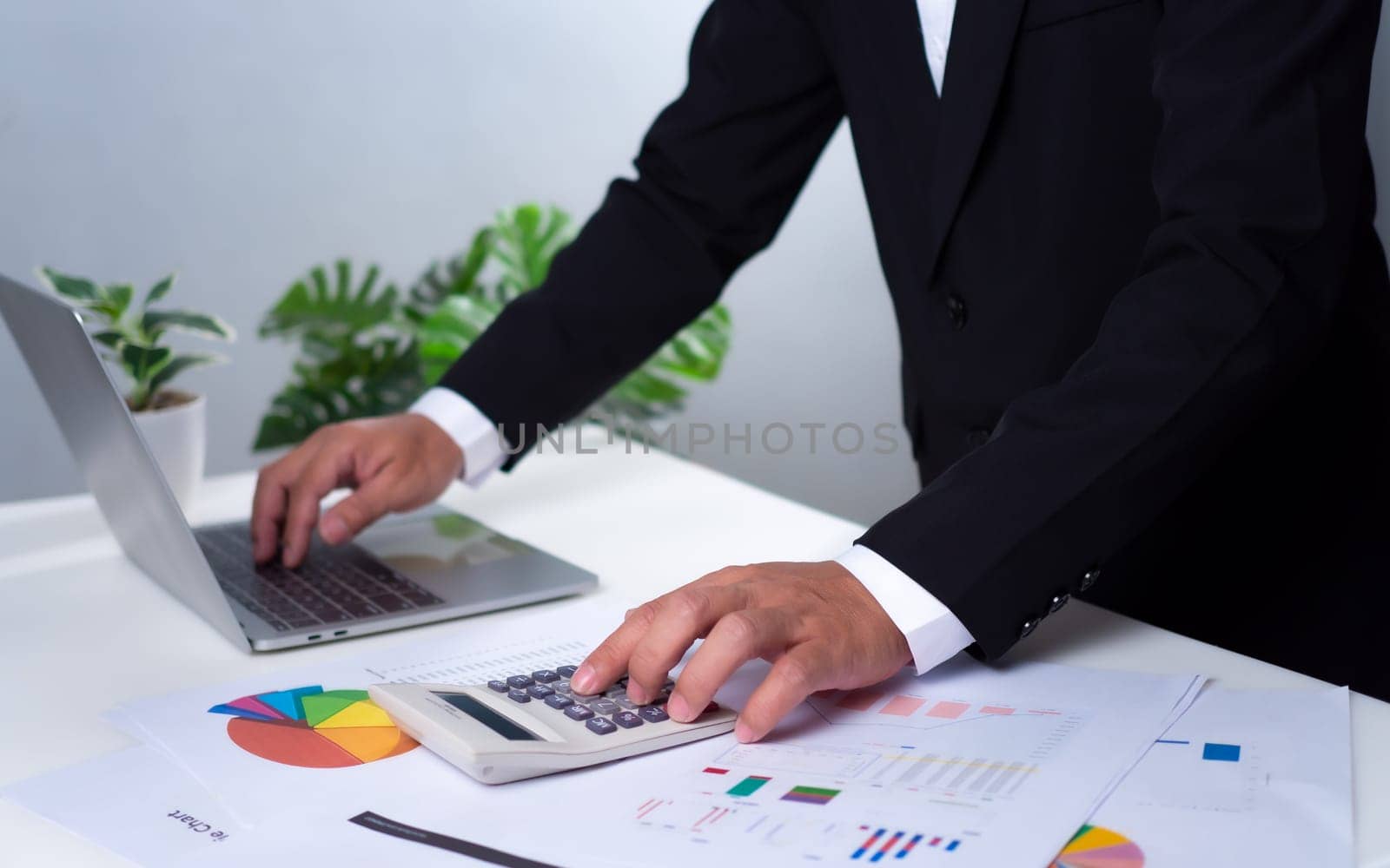 Business accounting concept. Business uses calculator with laptop computer, budget and income concept, sales concept, company accounting management. by Unimages2527