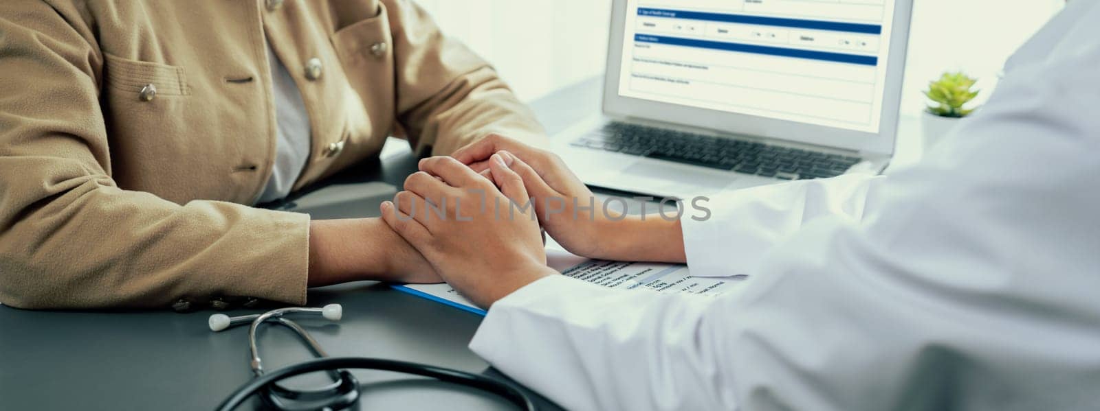 Doctor show medical diagnosis report and providing compassionate healthcare consultation while holding young patient hand for being supportive and professional in doctor clinic office. Neoteric