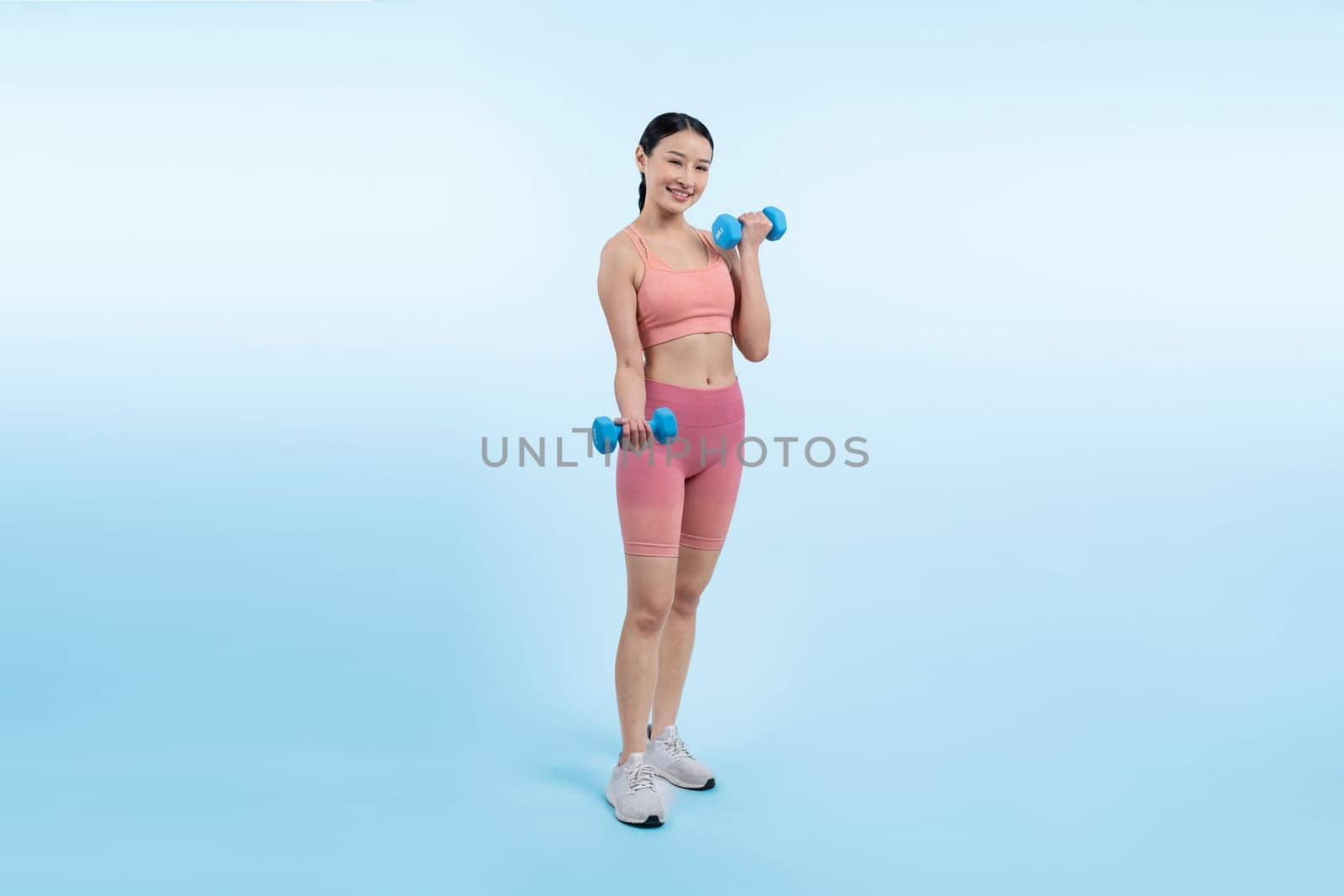 Vigorous energetic woman doing yoga with dumbbell weight exercise. by biancoblue