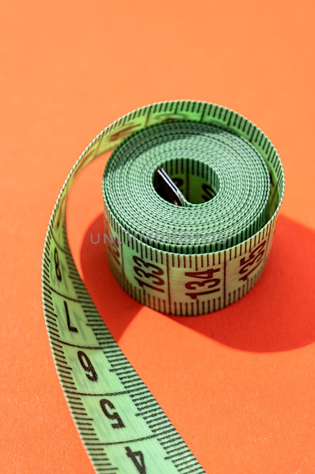 colorful measuring tapes top view on bright red background by Desperada