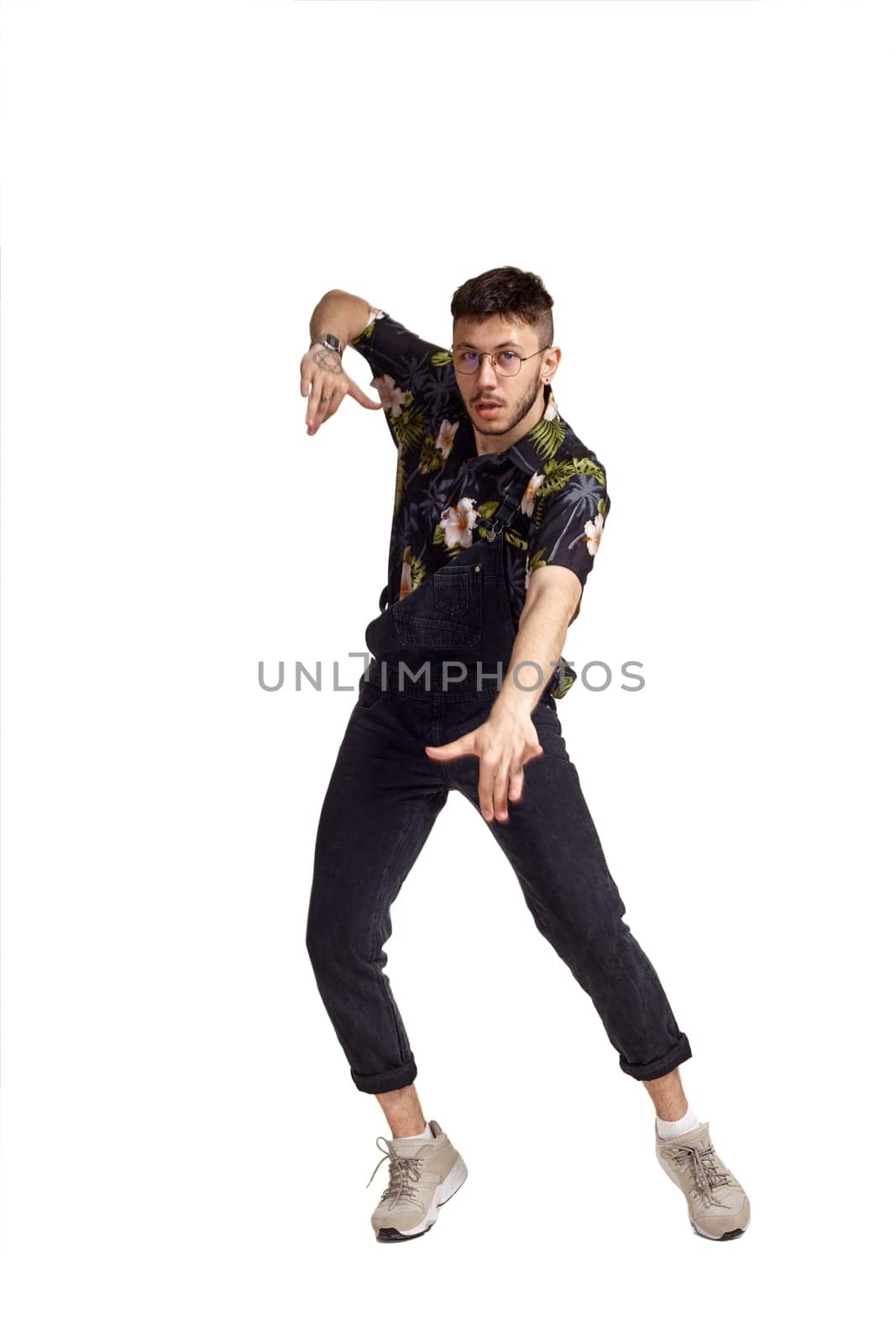 Full-length portrait of a funny guy dancing in studio isolated on white background. by nazarovsergey