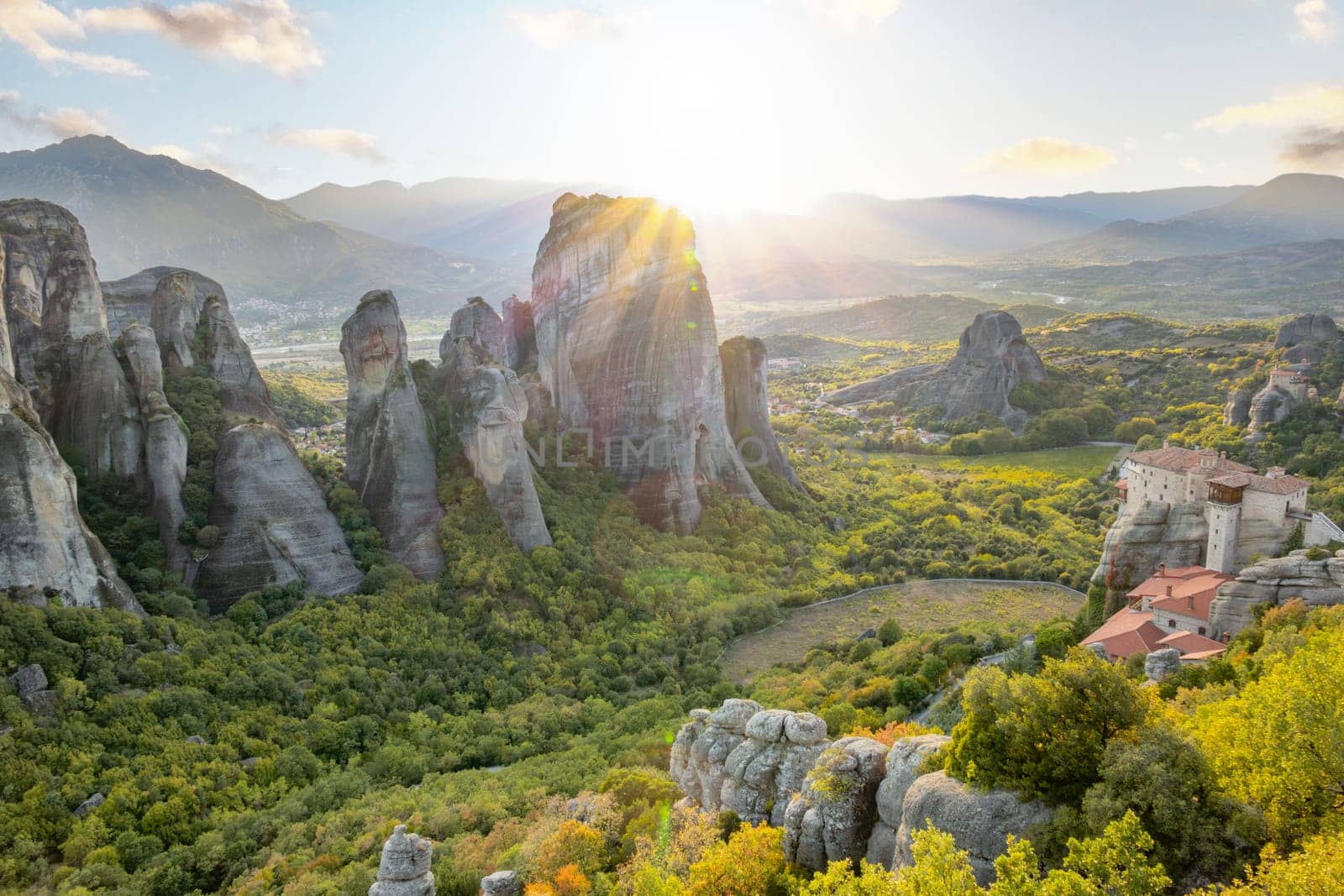 Northern Greece. The small rock monastery of Meteora in the mountains of Thessaly. Summer sunset rays over the green valley off Kalambaka