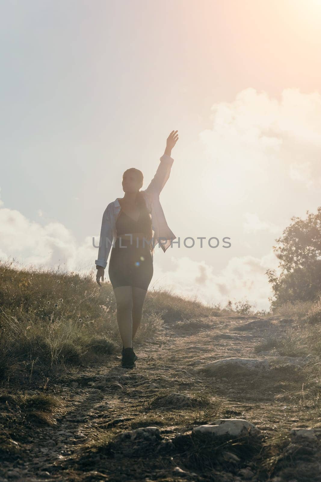 Woman travel sea. Young Happy woman in a long red dress posing on a beach near the sea on background of volcanic rocks, like in Iceland, sharing travel adventure journey
