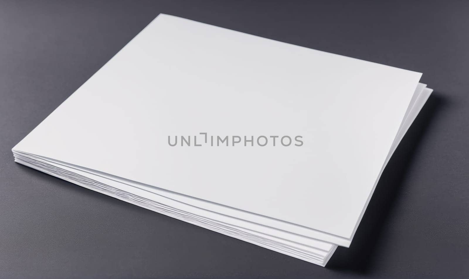 A stack of blank white paper lies flat on a gray surface. The paper is neatly stacked, and the edges are slightly visible.