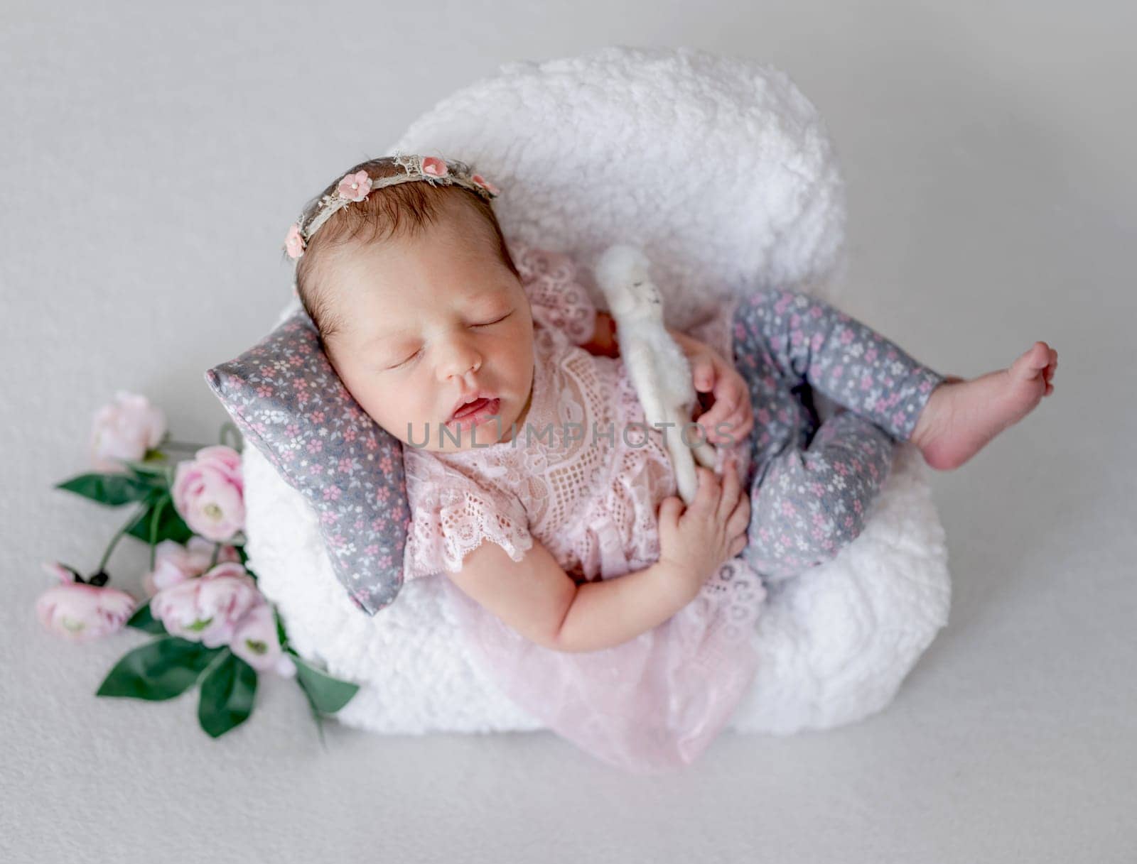 Baby Girl Sleeps On Tiny Chair In Newborn Studio Photo
