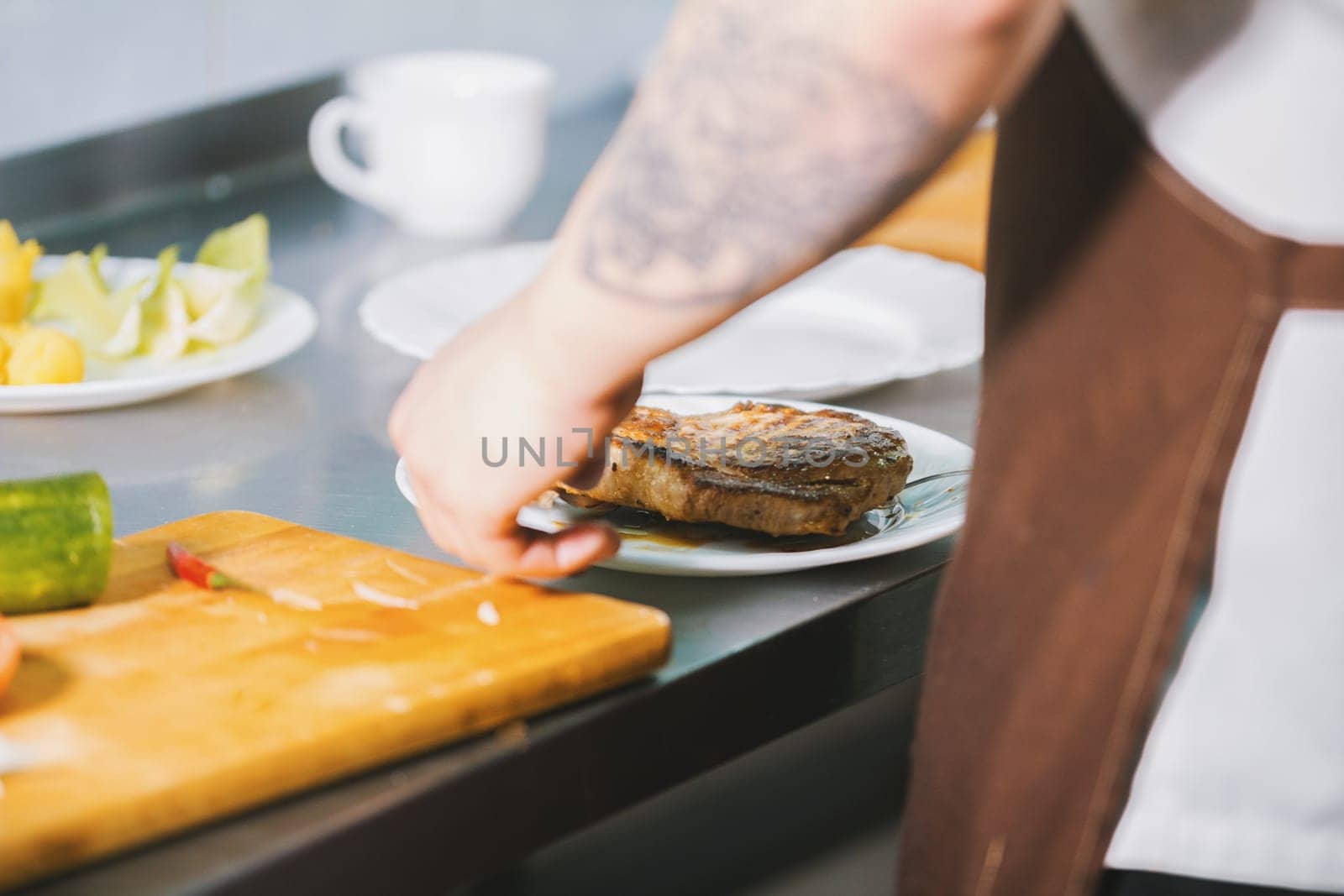 Chef serves meat on the plate in restaurant close-up