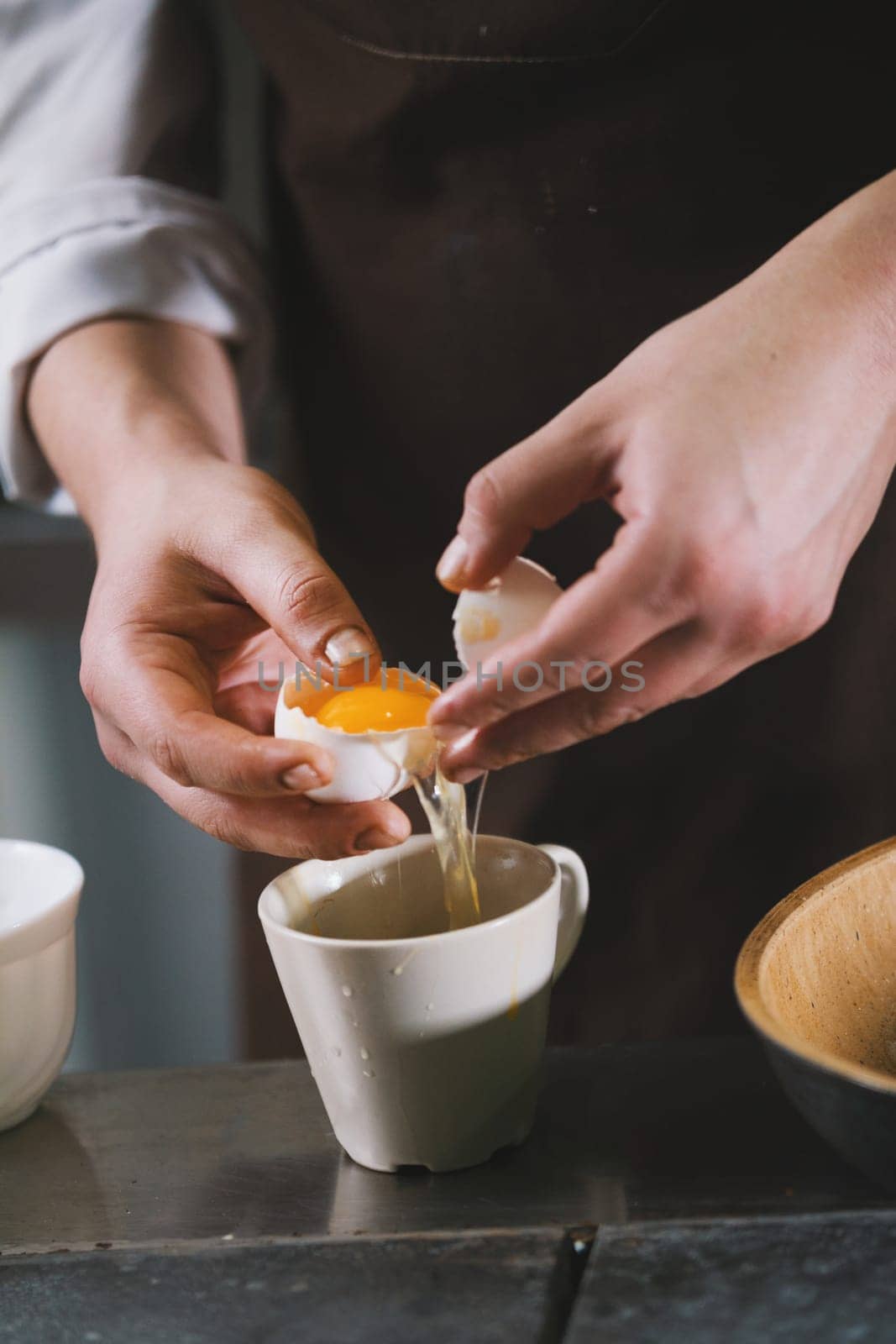 The chef separates the whites then yolks in restaurant close up