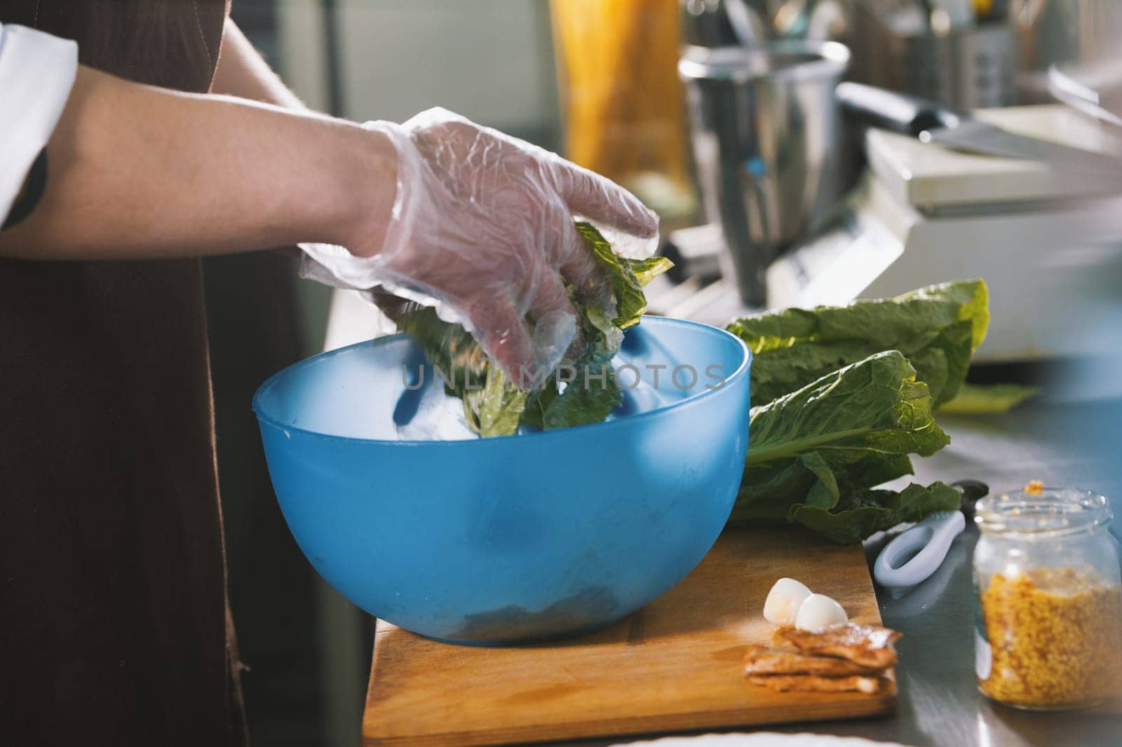 Male chef preparing salad in commercial kitchen close-up