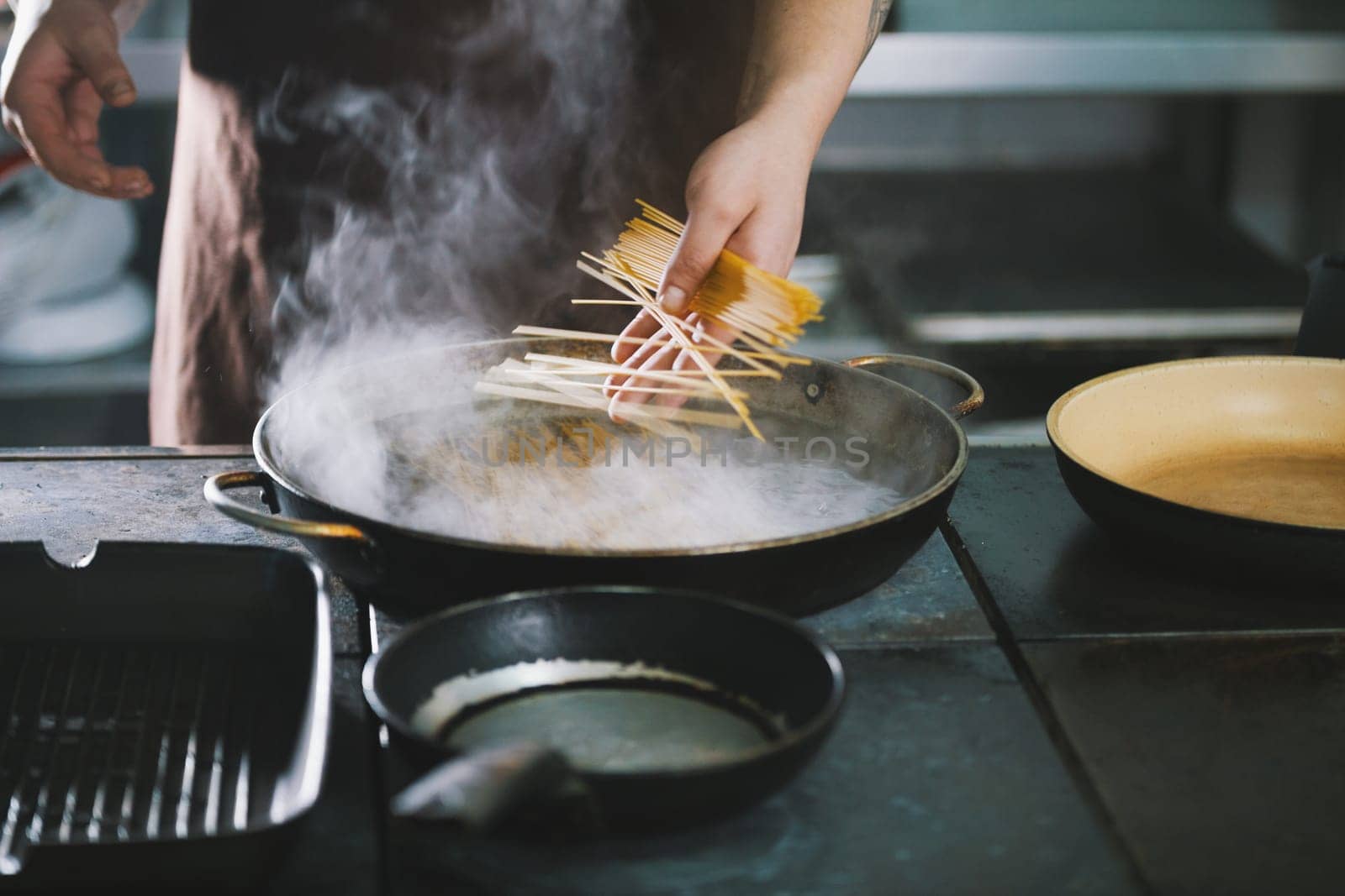 Professional cooking spaghetti in restaurant close-up