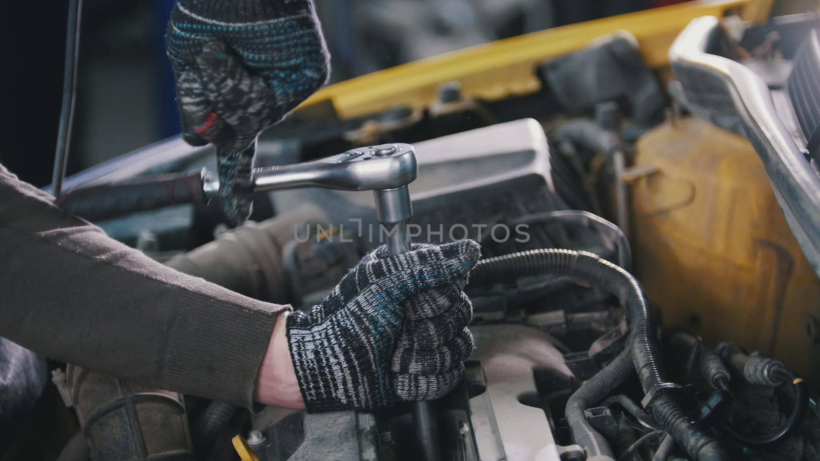 Car auto service working - mechanic unscrews detail of car, close up