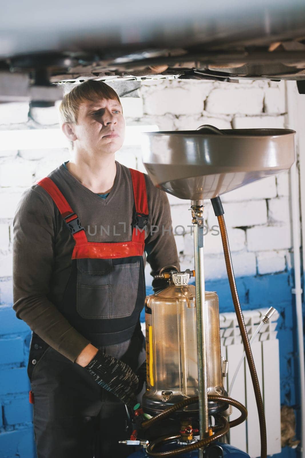 Portrait of a car mechanic in a car workshop, vertical