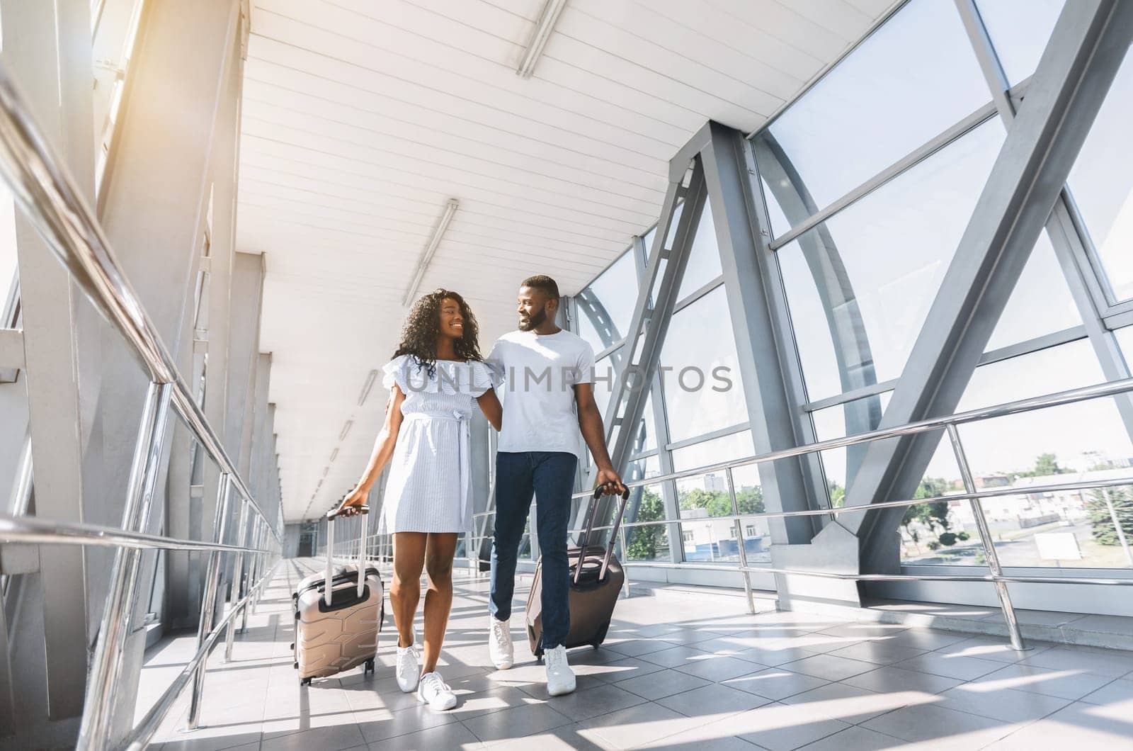 On way to honeymoon. African-american couple travelers with suitcases at airport, freee space