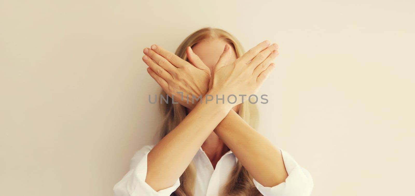 Upset woman shows stop, no or enough sign with palm of hand, refusal gesture, domestic violence.