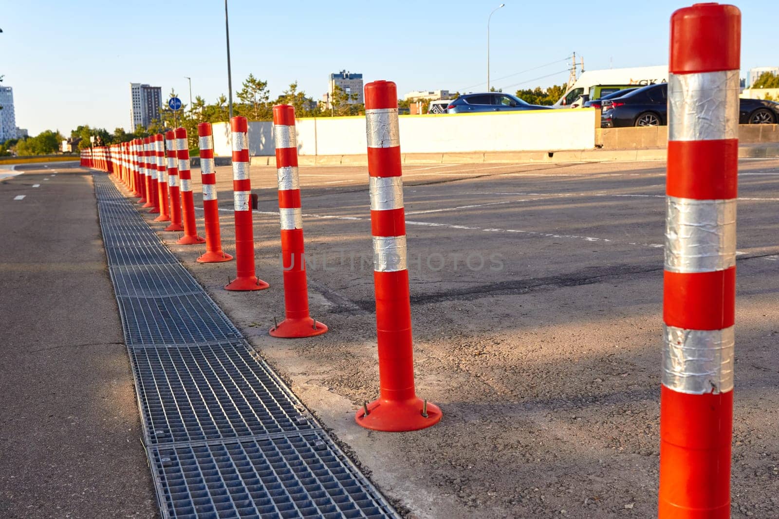 Rows of bright orange traffic cones installed on an asphalt road to delimit traffic