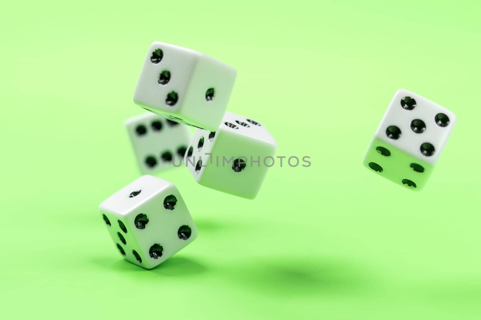 A conceptual photo of dice being rolled on a green table.