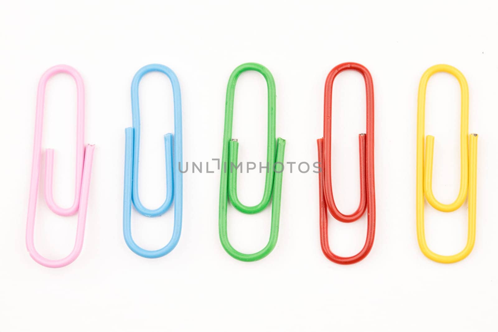 A concept photo of multi-colored paper clips on a white background.