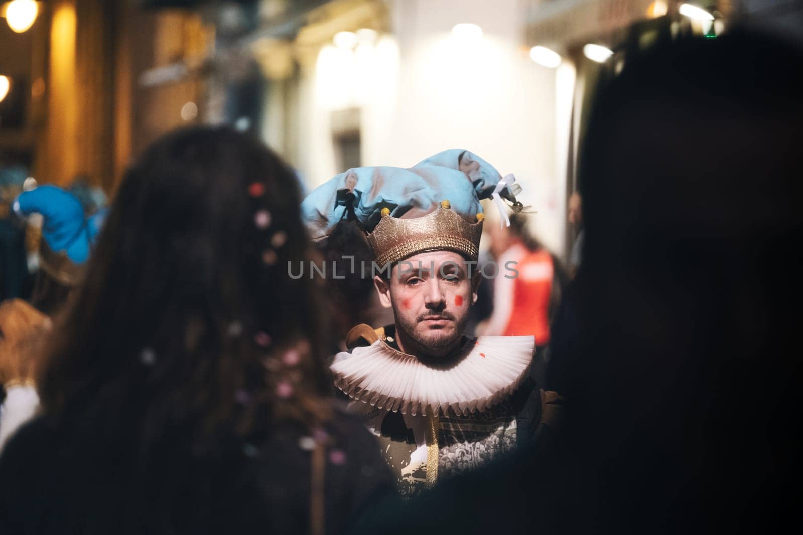 man who is central in the frame. He wearing a costume with a large collar reminiscent of styles from the Elizabethan era