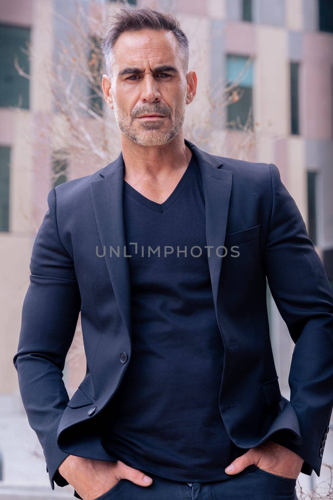 Close-up of a caucasian businessman looking angry at the camera in a suit standing in outdoor workspace. Front view of a young lawyer with thoughtful expression staring