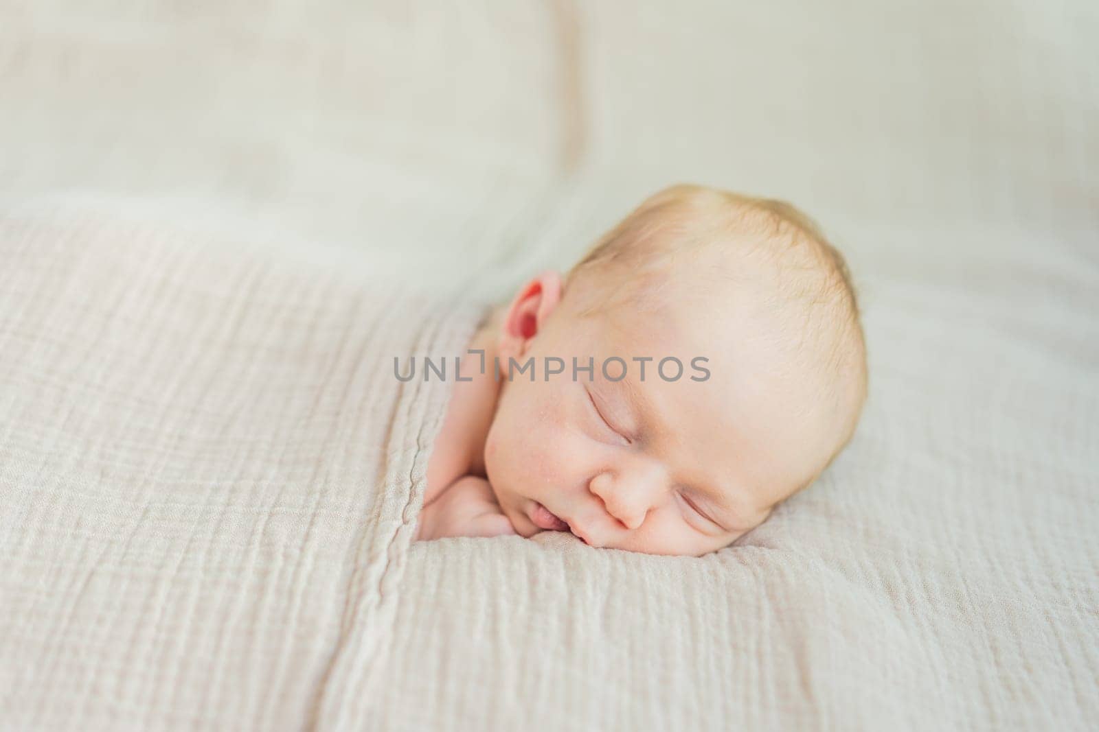 The baby is sleeping peacefully in his cozy nest. Newborn photo session captures the serene innocence and warmth of early moments.