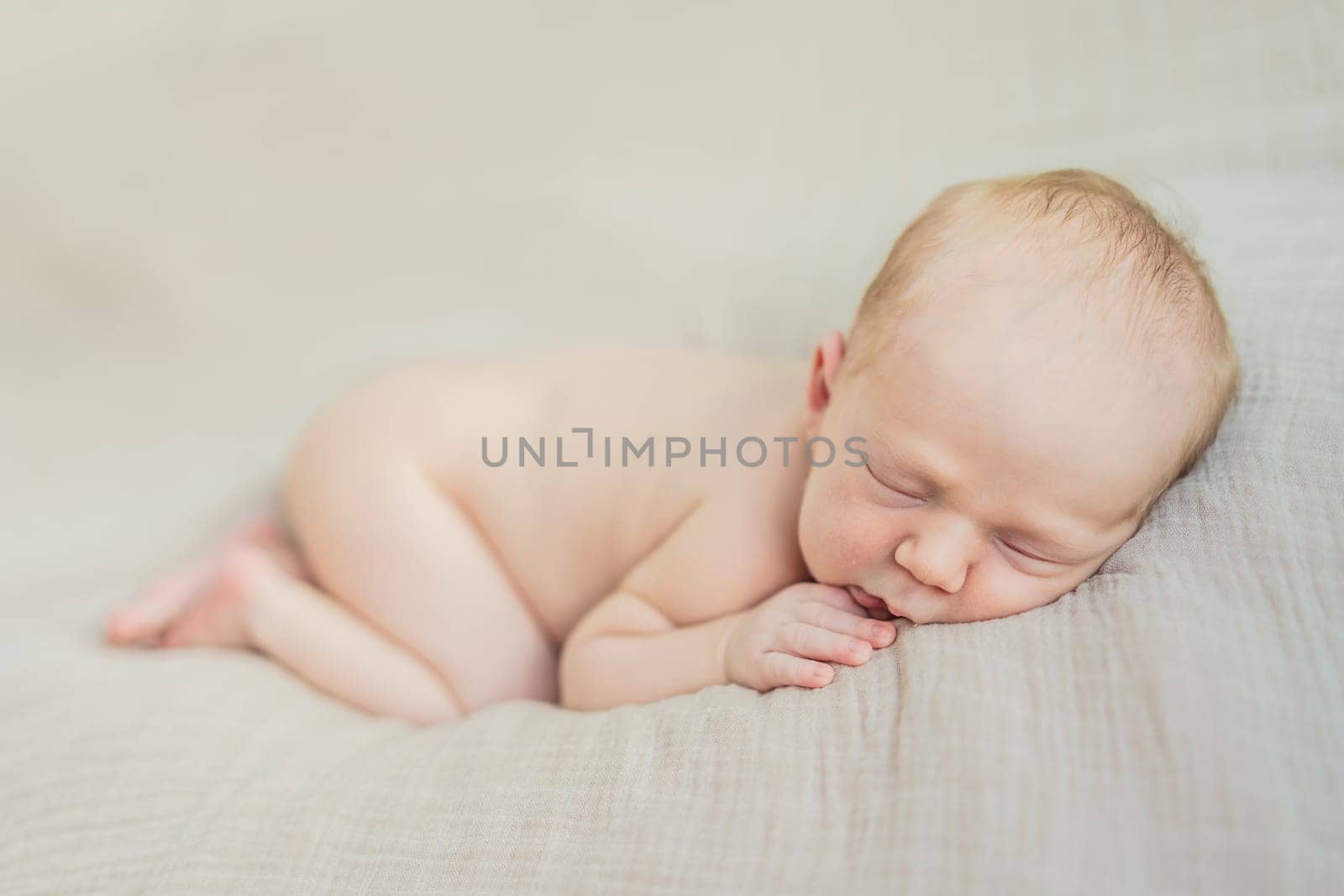 The baby is sleeping peacefully in his cozy nest. Newborn photo session captures the serene innocence and warmth of early moments.