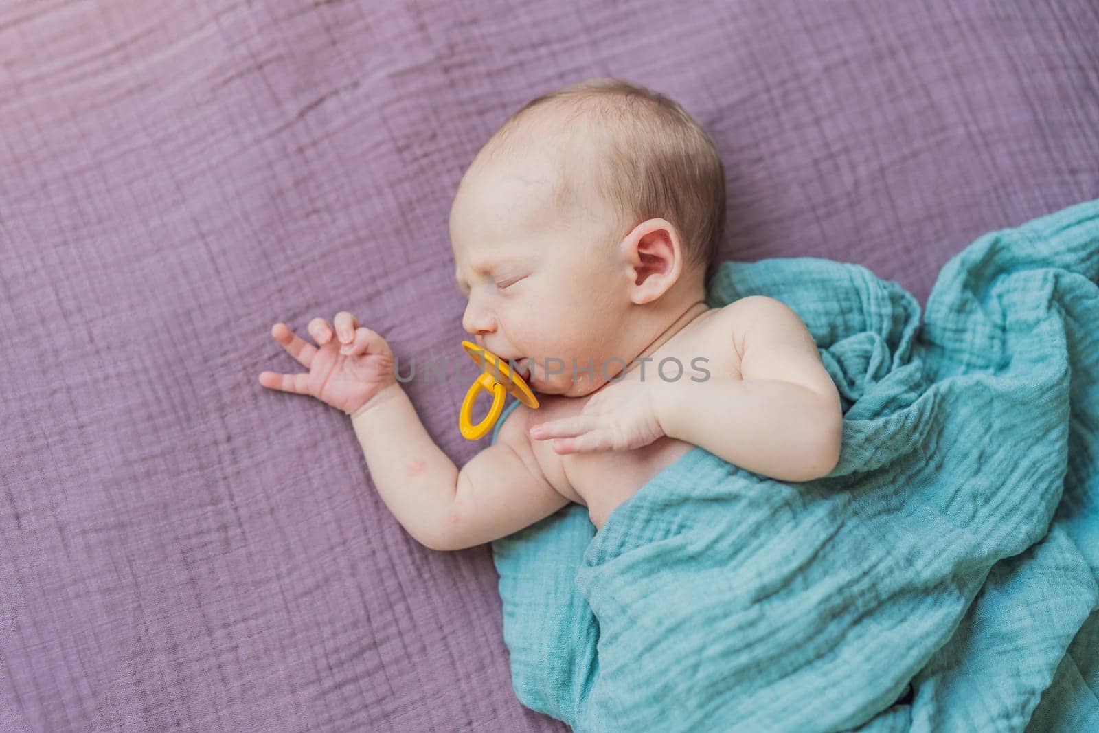 The baby is sleeping peacefully in his cozy nest. Newborn photo session captures the serene innocence and warmth of early moments.