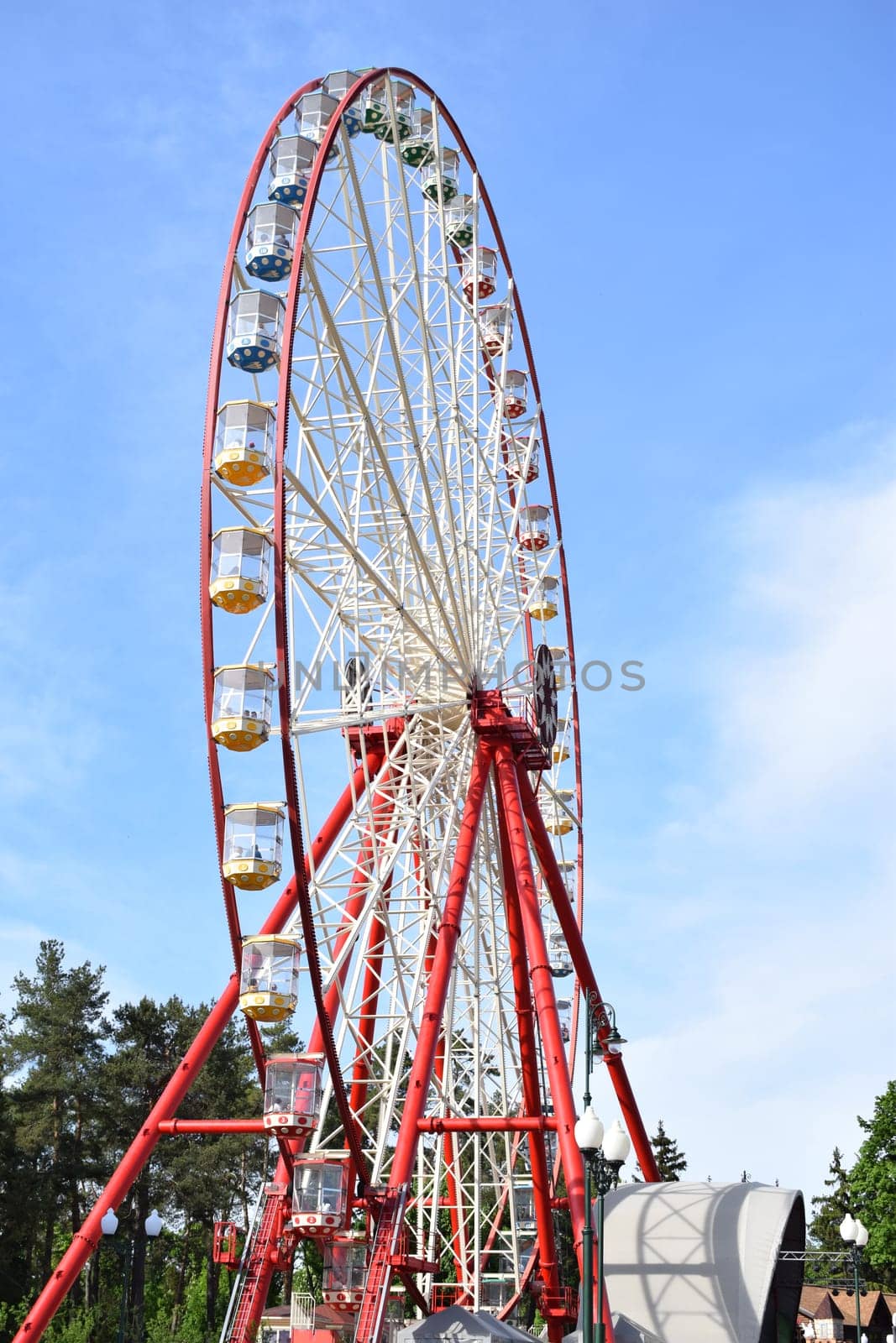 Ferris wheel against the blue sky in the city park with copy space.