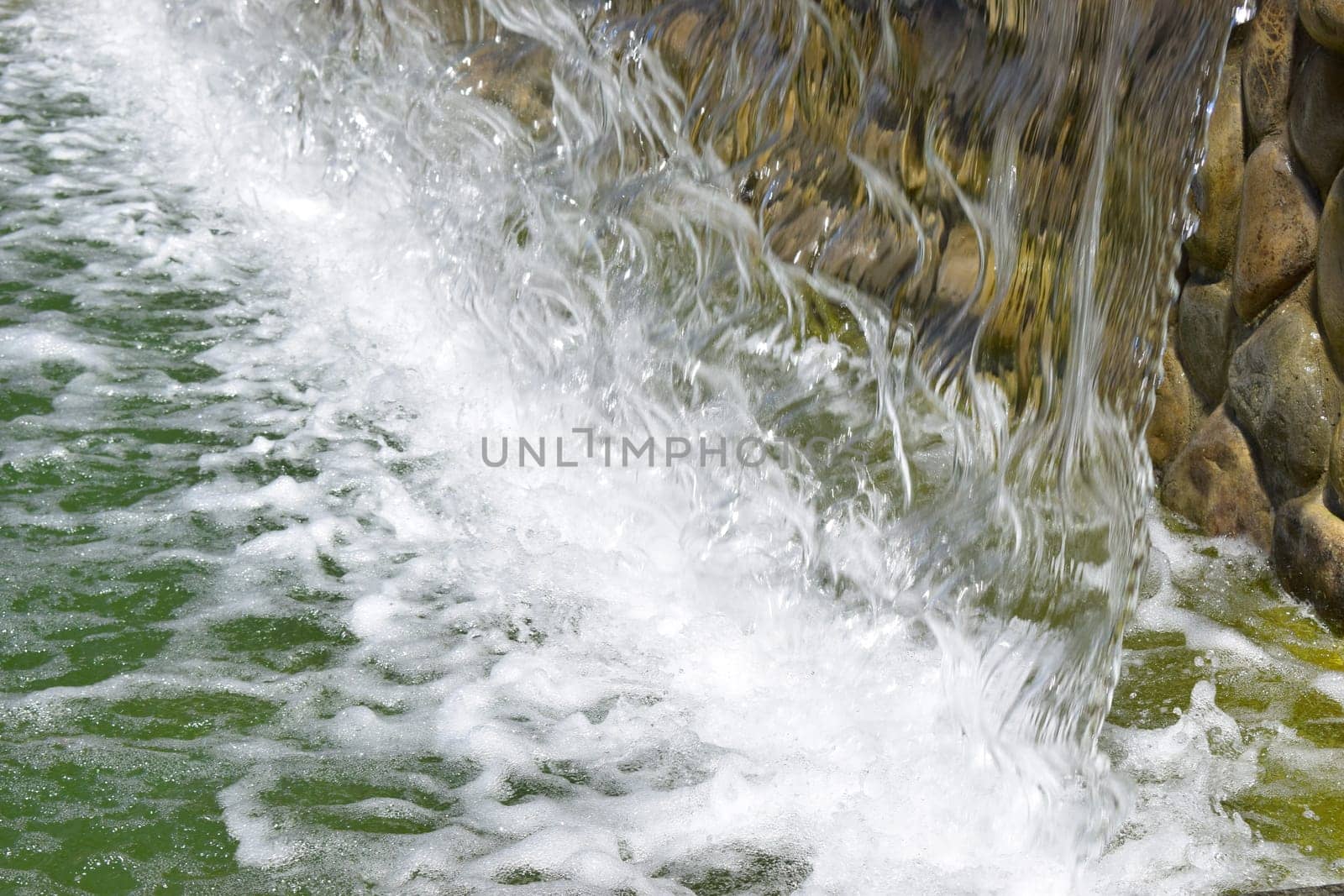 artificial waterfall, city fountain, close-up pouring water.
