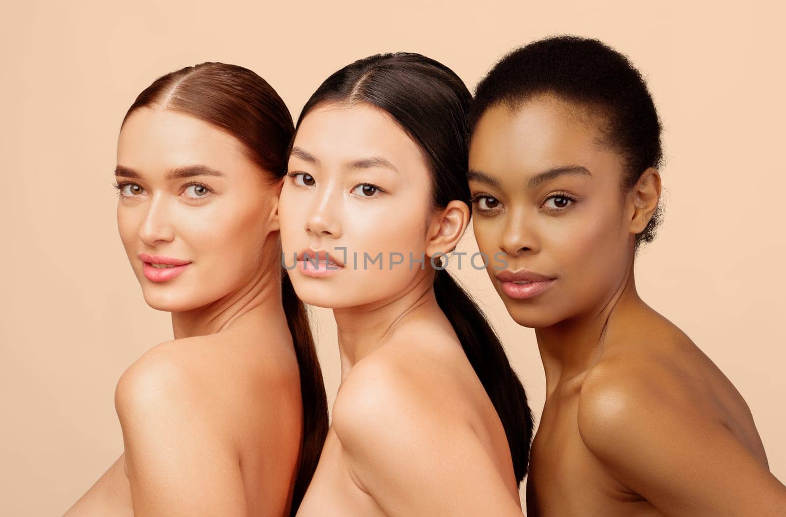 Portrait Of Three Pretty Girls Posing Looking At Camera In Studio On White Background. Female Beauty And Sensuality.