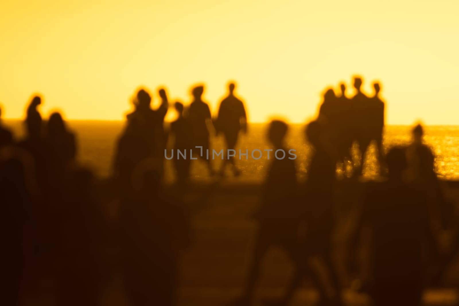 Silhouettes of people at yellow bright sunset by Studia72