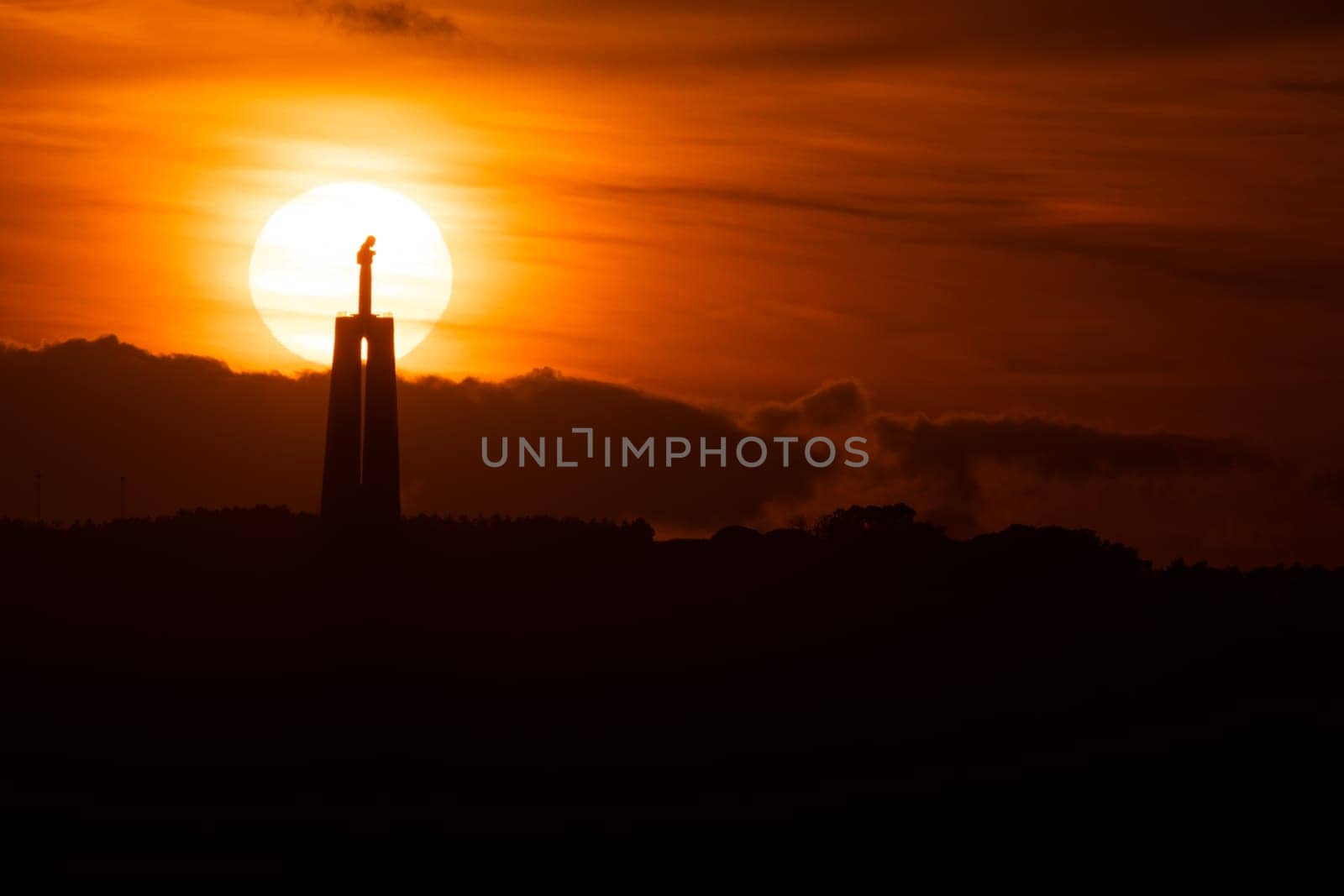 Statue of Jesus Christ at bright orange sunset by Studia72