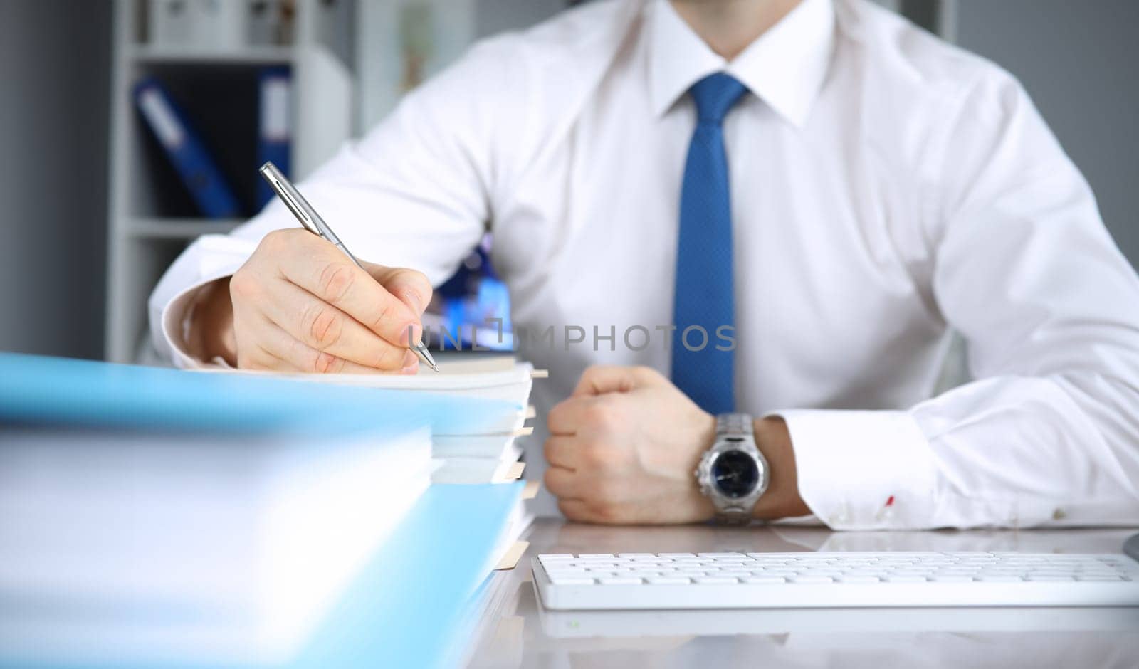 Man makes notes in documents at his desk. Time management and planning concept