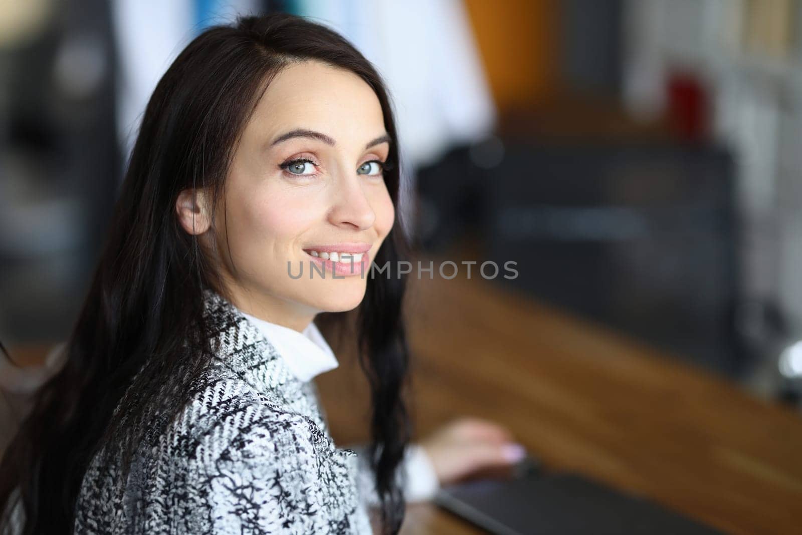 Portrait of smiling brunette woman in the workplace by kuprevich