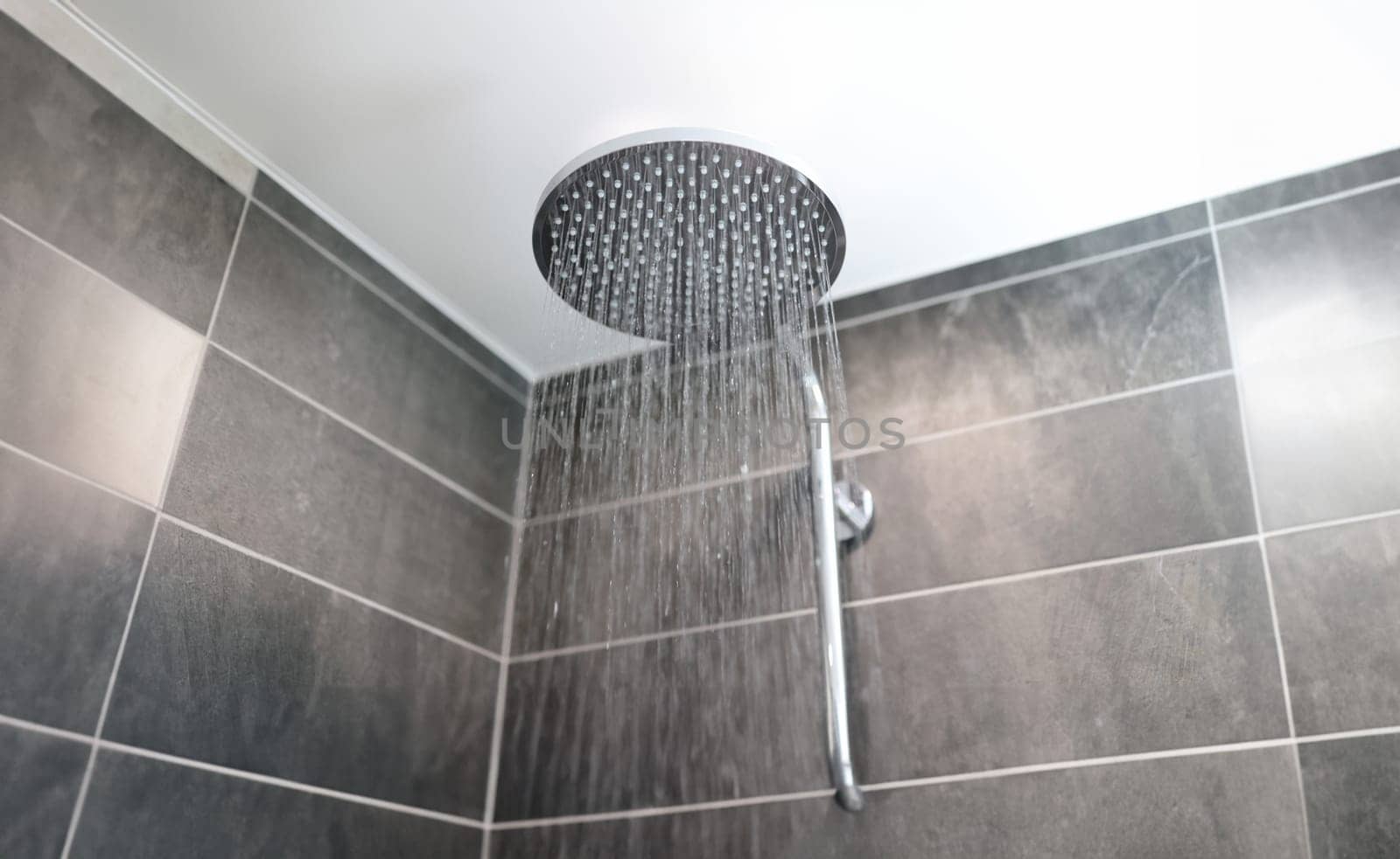 In bathroom, water flows from shower tap by kuprevich