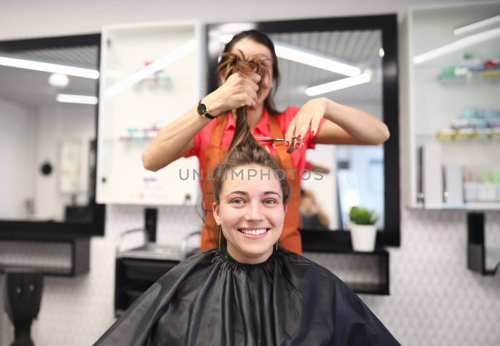 Portrait of smiling woman in hairdressing salon, which master cuts her hair by kuprevich