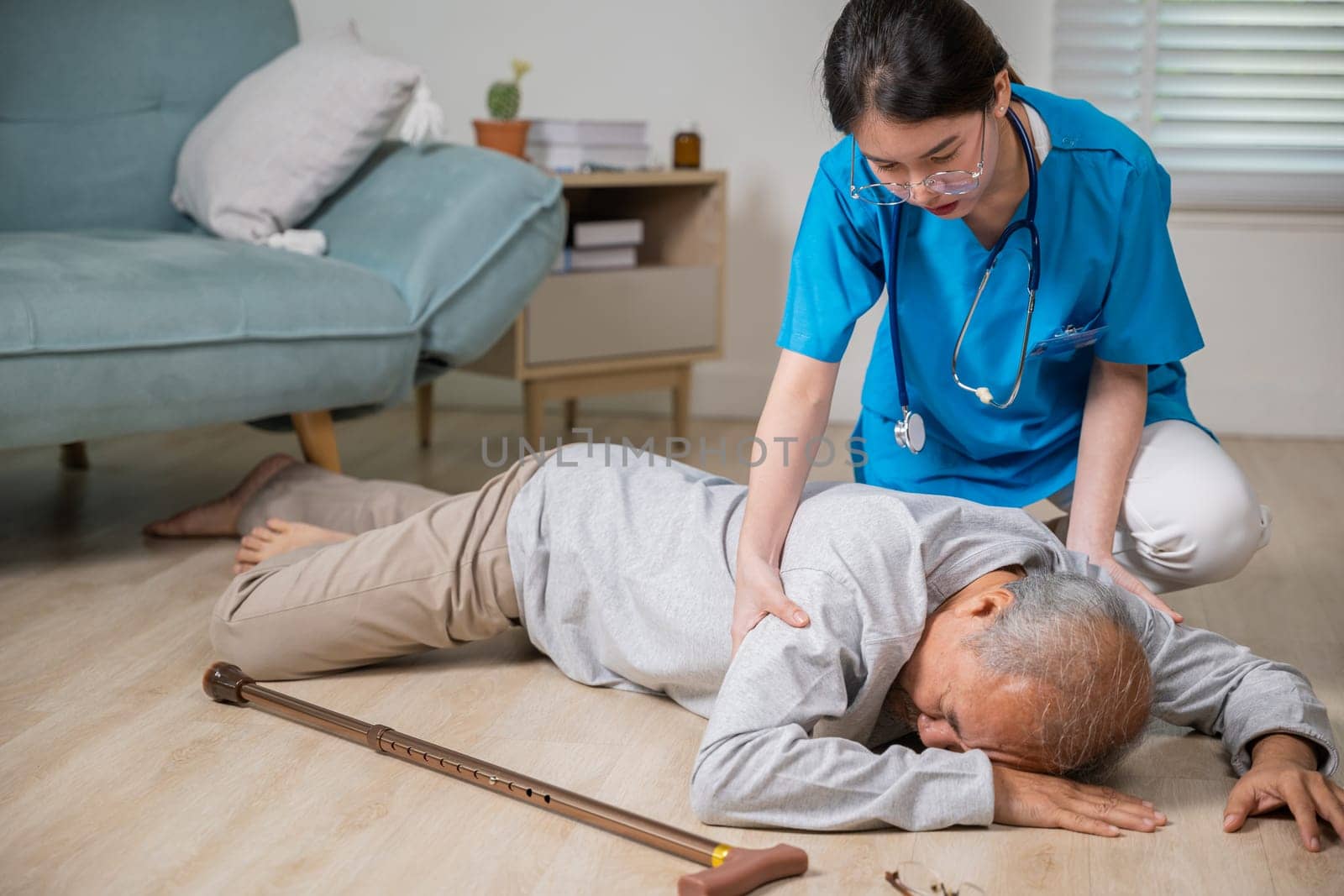Disabled elderly man patient with walking stick fall on ground and caring assistant by Sorapop