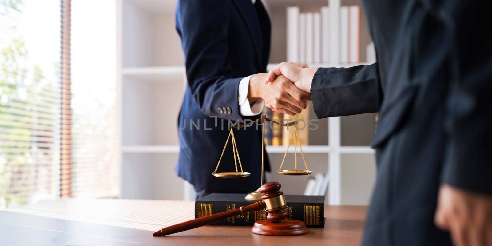 Businessman shaking hands to seal a deal with his partner deal lawyer or attorney discussing a contract agreement. legal, lawyer, real estate, justice concept by nateemee