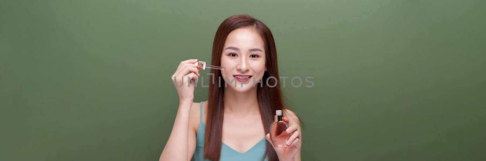 beautiful female using anti-aging treatment product on green,panorama