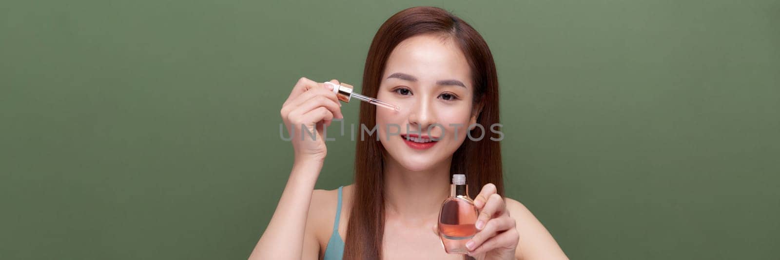 Crop young female applying serum on face, banner
